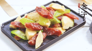 熱油下鍋，依次下金字香腸、萵筍、冬筍，均勻翻炒。