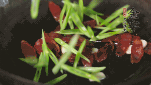 先后下香腸片、四季豆絲均勻翻炒，加適量清水燜煮一下。