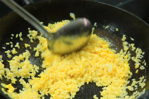 大火加熱炒鍋，再入油，燒到四至五成熱時倒入雞蛋液，在未凝結之前，加米飯煸炒，不停翻炒并用鍋鏟將成塊的米飯碾開、撥散。