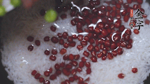 將炒好的食材和大米、紅豆一起放進(jìn)電飯鍋煮。