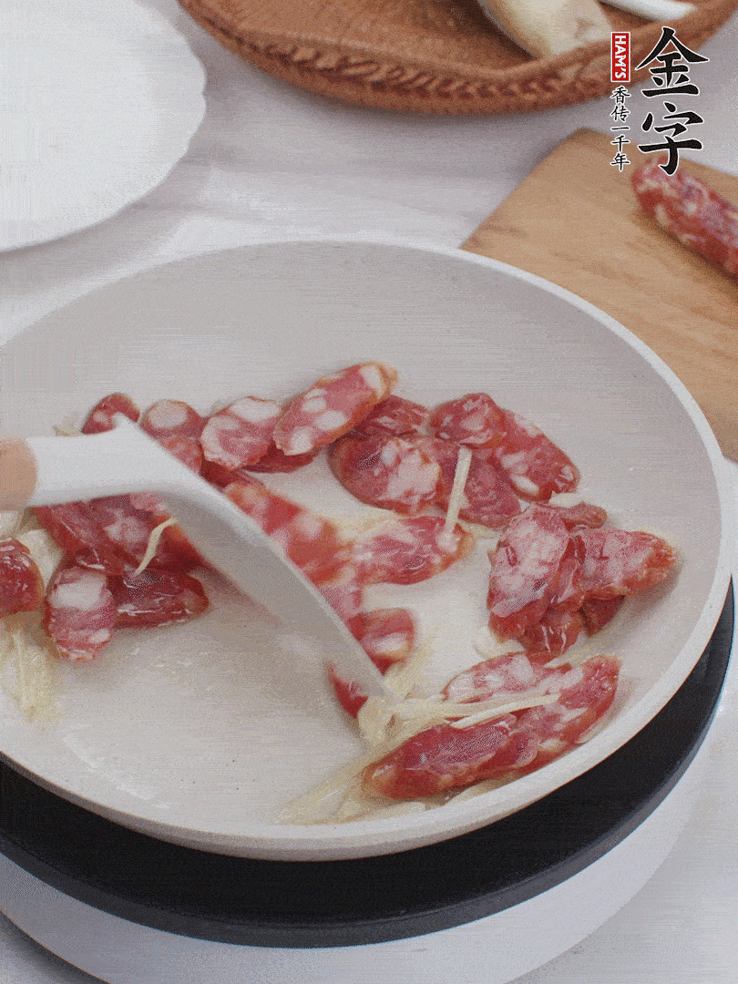 油溫3成熱時，下姜絲、蒜片、香腸炒出油脂。