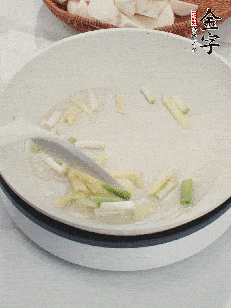 鍋中油五成熱，下蔥白、姜片爆香。