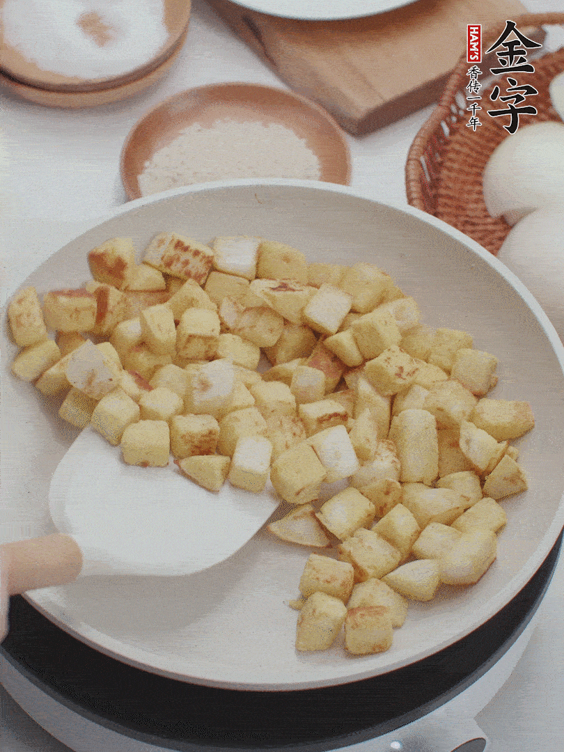 起鍋熱油，倒入饅頭丁，小火煎至蛋液凝固定型再翻面，饅頭丁部煎至金黃時盛起待用。