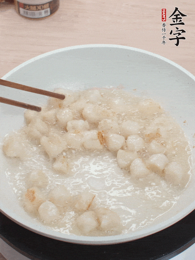 油溫4成熱，鮮貝蘸干淀粉下鍋煎，一面微黃后翻面。