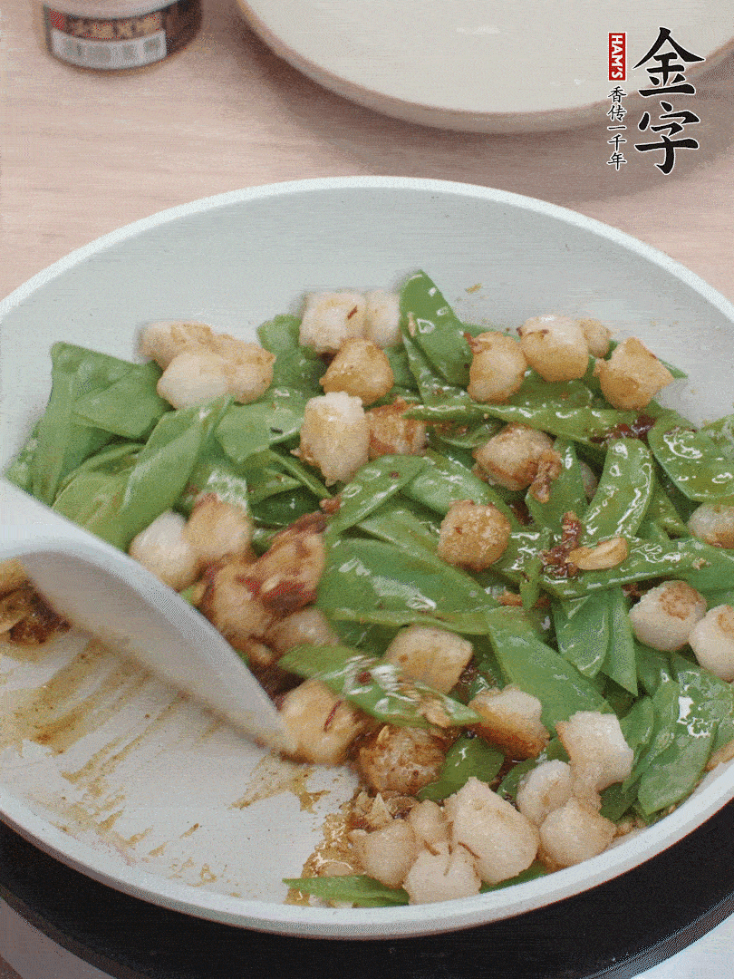 下甜豆莢、鮮貝輕輕翻炒均勻。