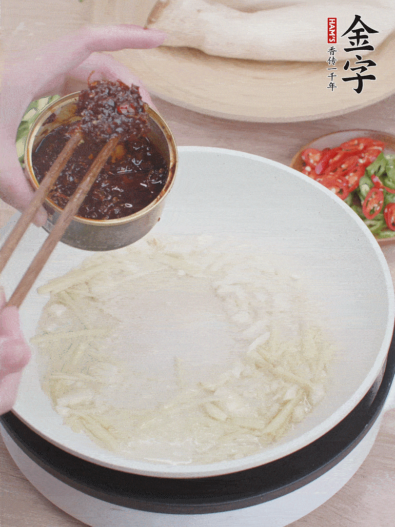 起鍋熱油，姜蒜、金字火腿干貝醬煸香。