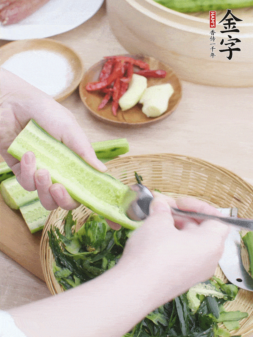 黃瓜削皮，對半切開，勺子挖去內(nèi)瓤，斜刀切片。青蒜斜刀切段。