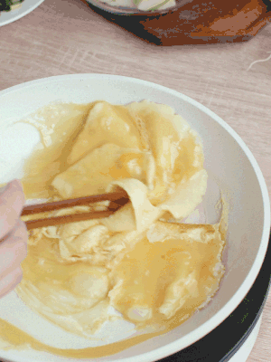 油6成熱時，下雞蛋液，邊緣凝固時翻拌成塊狀。