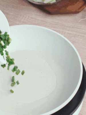 熱油下臘肉、蔥花煸炒，再下西葫蘆。