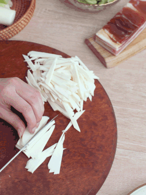 茭白切細(xì)絲，鹽水中浸泡防止氧化。