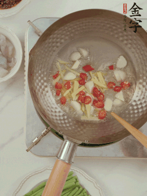 油7成熱時(shí)，下大蒜粒、姜絲、小米辣煸香。