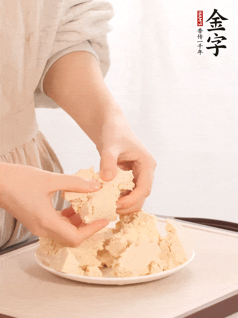 老豆腐用手掰成塊。