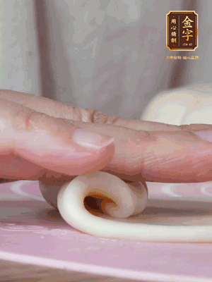 做面劑 油皮按扁，中間包入一個(gè)油酥，邊緣收緊捏死。包好的面劑按扁，用搟面杖搟壓成橢圓形。從底部向上卷成筒狀，用保鮮膜蓋好松弛15分鐘，再把筒狀縱向搟壓成長(zhǎng)條狀。再卷一次，松弛20分鐘