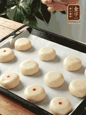 收口向下放在案板上，輕輕將月餅坯按扁，用筷子點(diǎn)紅點(diǎn)做裝飾