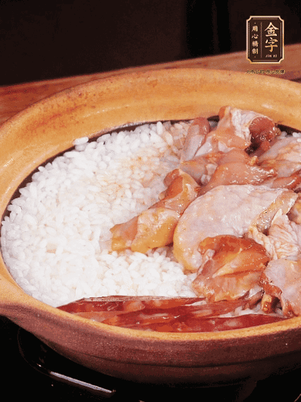 煮到椰子水微微收干轉(zhuǎn)小火，快速均勻鋪上雞肉、金字香腸